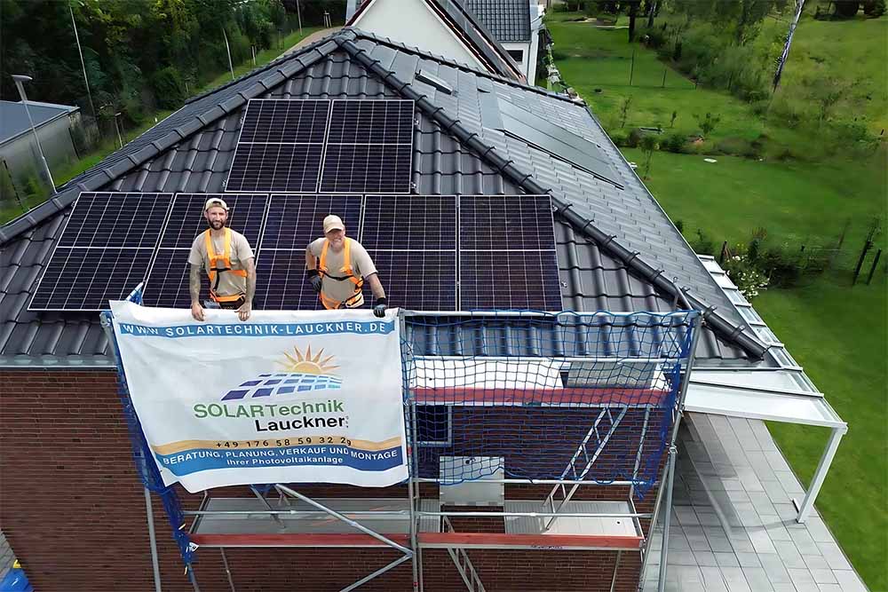 Monteure auf Dach mit PV-Anlage